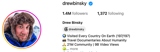 Drew Binsky, a global travel creator, smiling outdoors in a vibrant international destination surrounded by local scenery.
