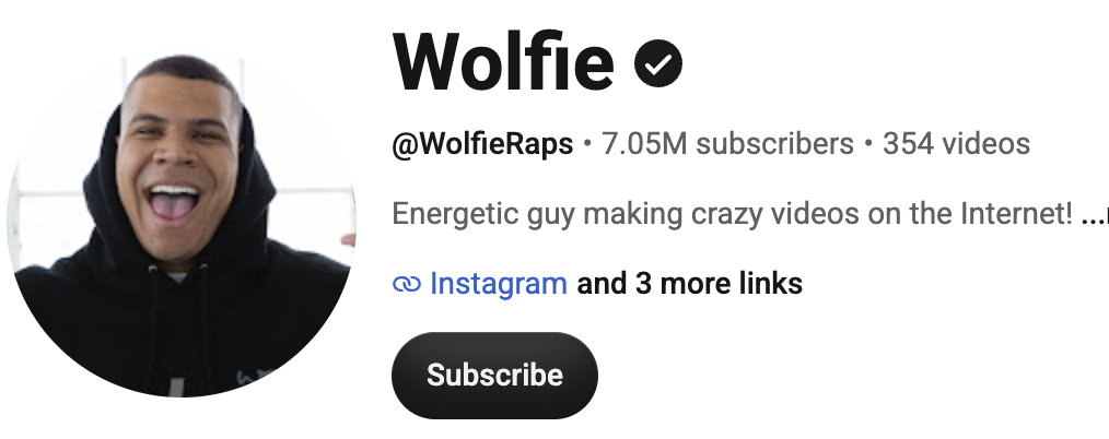 WolfieRaps, a gaming and entertainment creator, posing energetically in a colorful YouTube-style studio setting.