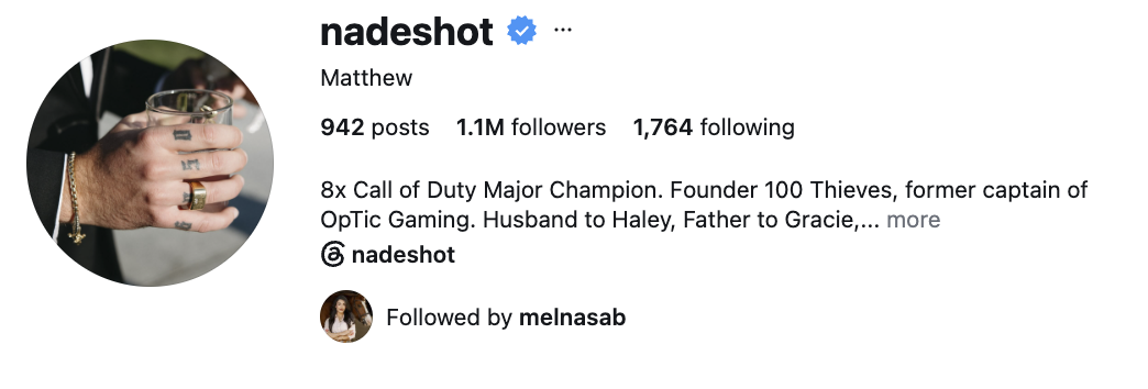 Nadeshot, an esports founder and former professional player, posing in a modern gaming or 100 Thieves environment.